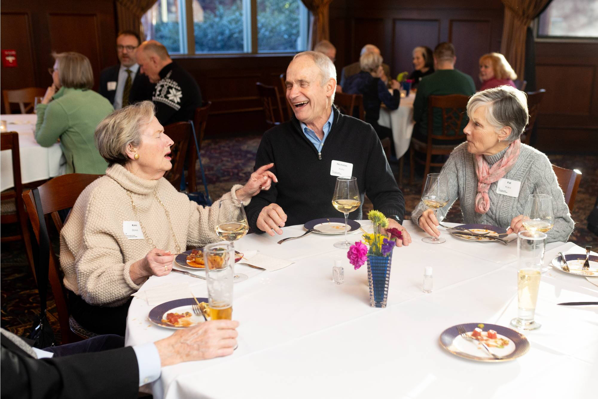 Members laugh during event reception